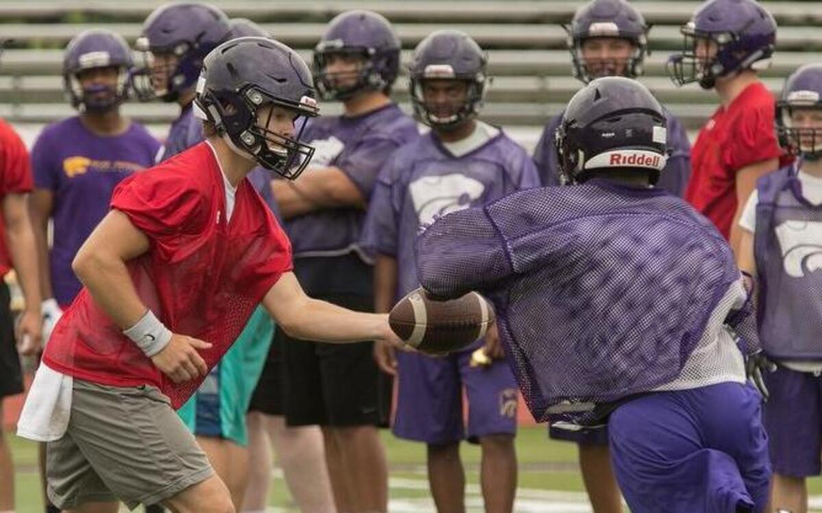 Blue Springs quarterback Chase Donohoe handed off the ball on Monday, July 31, 2017, during the first day of high school football practice for Missouri high schools.