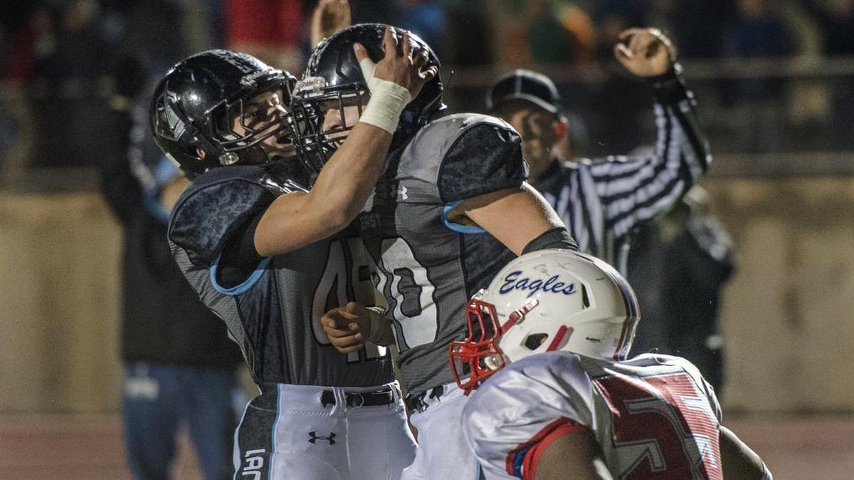 Shawnee Mission East’s Wyatt Edmisten (center) was congratulated by a teammate after scoring a touchdown in the Lancers’ victory over Olathe North last year in a Kansas Class 6A state semifinal playoff game. SM East won the thriller, 36-35, in double overtime. The two teams will play Friday in a Kansas quarterfinal game.