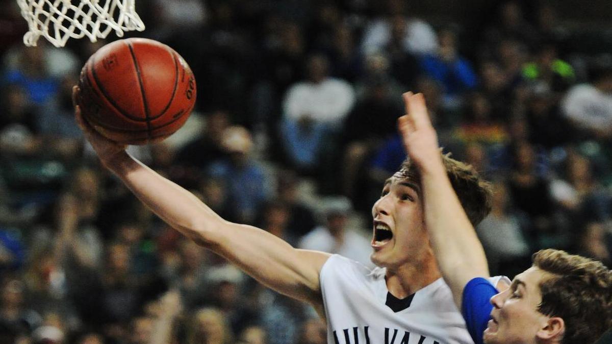Mill Valley’s Jaison Widmer goes to the basket on a breakaway ahead of Kapaun defender Christopher Meitzner on Saturday in their Kansas Class 5A state championship game. Mill Valley won in overtime, 87-84.