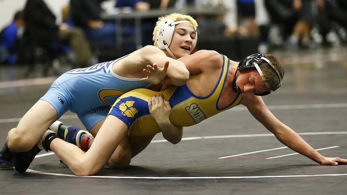 Olathe South’s Jace Koelzer (left) took Hutchinson’s Brian Gates to the mat and won the Kansas 6A state championship at 106 pounds Saturday in Park City, Kan. Koelzer won a 4-0 decision.