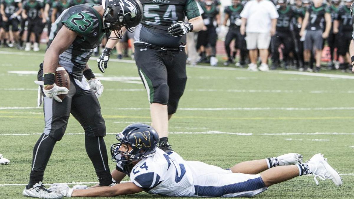 Staley High School’s Julian Ross stood over Edmundo Chacon of Lee’s Summit North after he scored a touchdown in the third quarter of their game, which started last Friday night then resumed on Saturday due to a weather delay.
