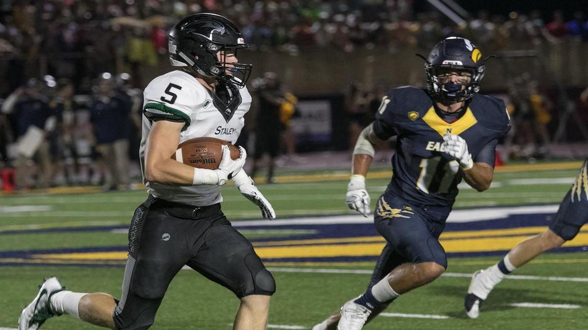 Aaron Keast of Staley (left) tried to get around and past the Liberty North defense at Liberty North on Friday night. It was the first-ever game at Liberty North’s new stadium, Crossley Family Activity Complex.
