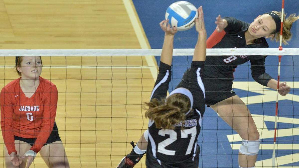 Blue Valley West’s Peyton Uhlenhake (right) slammed a shot against a Blue Valley Northwest opponent during the Kansas Class 6A volleyball state tournament title match recently in Topeka.