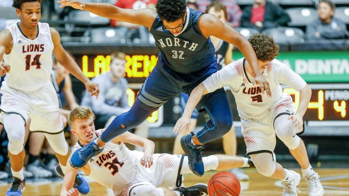 Blue Valley North's Miles Emery (center) gets pressured by Lawrence's Jackson Mallroy (31) and Austin Miller (right) during their Kansas Class 6A semifinal gam Friday. Blue Valley North lost to Lawrence 41-36 on its way to a fourth-place finish.