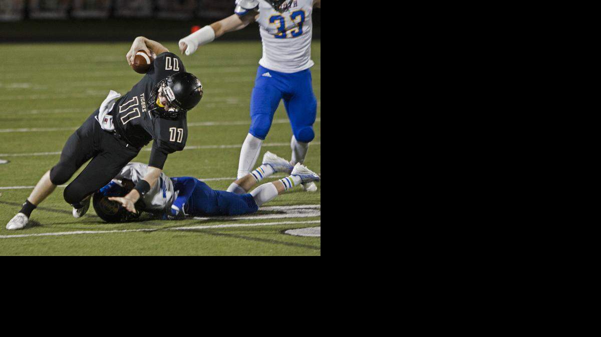 
Colton McCumber (with ball) of Blue Valley was upended by Olathe South’s Stephan Miller during their game last Friday night at Blue Valley. The Tigers defeated Olathe South 49-0.
