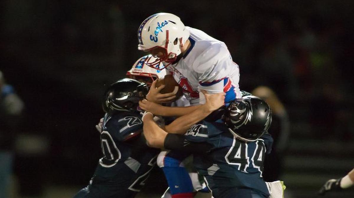 Blue Valley North defenders stopped Olathe North quarterback Matt Wright after he scrambled for a first down during their game on Friday night.