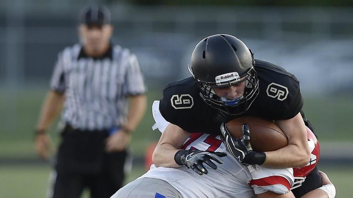 Blue Valley’s Harrison Van Dyne (with ball) gained yardage before Bishop Miege’s Joe Watskey and Cameron Key (on ground) slowed his progress. Blue Valley downed the Stags, 35-28, in their season opener on Friday night at Blue Valley High School.