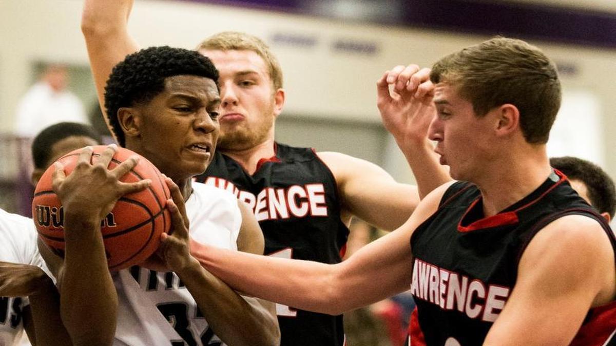 Tyson Campbell (32) of Lee's Summit West competes for the ball with Price Morgan (11) and Braden Solko (2) of Lawrence during Thursday’s 21st Hy-Vee Shootout game at Avila University. Lee's Summit West lost, 62-59.
