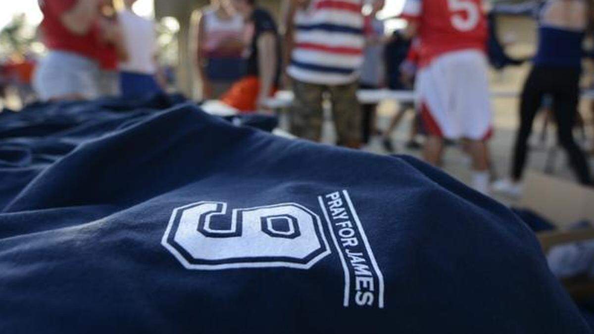 
Olathe East High School students and parents sold T-shirts bearing the football jersey number of James McGinnis before the start of Friday’s Olathe East- Shawnee Mission South football game at the College Boulevard Activity Center. McGinnis remains hospitalized after he collapsed on the field during a football game on Sept. 12. Proceeds from the T-shirt sales are for the James McGinnis Fund. 
