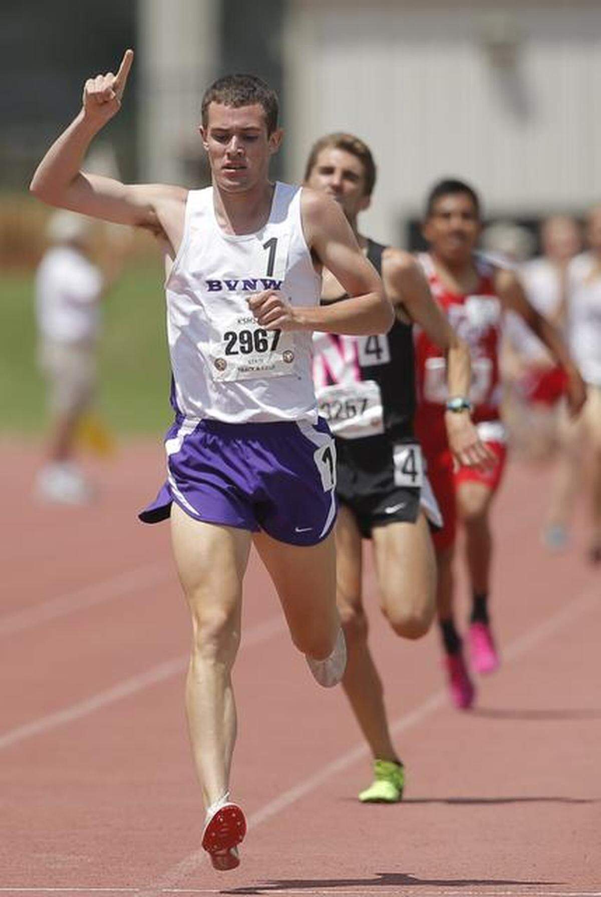 Samuel Guinn of Blue Valley Northwest raises his finger after an easy win in the class 6A 1600 meter run on Saturday during the Kansas Track and Field State Championships at Cessna Stadium.