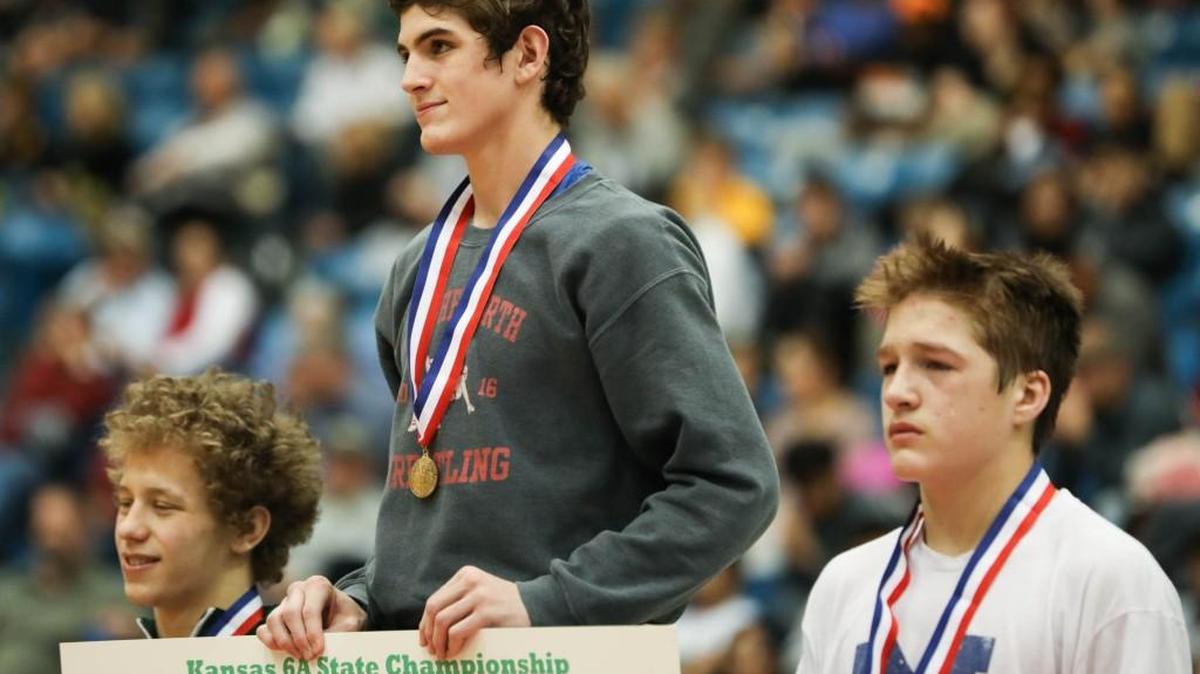Olathe North’s Riley Alderman stands atop the podium after winning the 132-pound division in the Kansas Class 6A state wrestling tournament at Hartman Arena in Park City. Alderman was one of four Olathe North state champions.