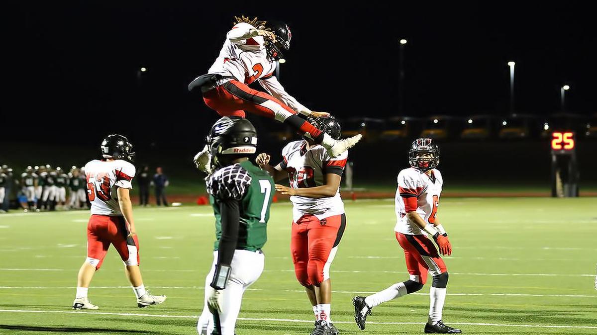 Park Hill’s Zach Neal (in air) and offensive lineman Jamar Grant (No. 70) celebrate Neal’s touchdown on Friday night against Staley.