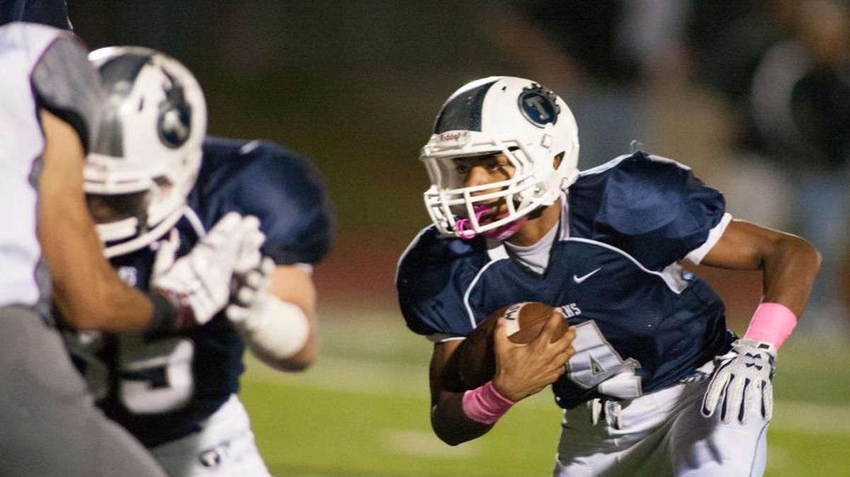 Lee’s Summit West sophmore running back Phillip Brooks looks for running room against Lee’s Summit North during their game on Friday night. The Titans defeated Lee’s Summit North, 34-14.