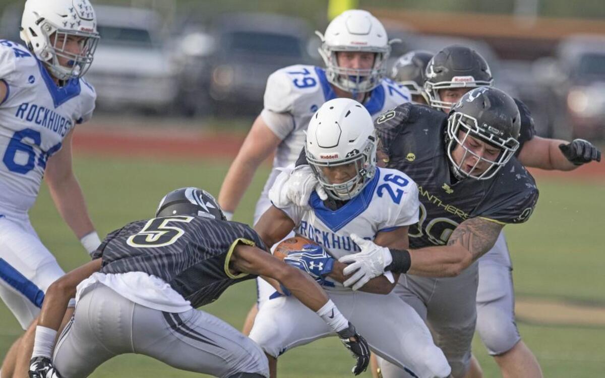Rockhurt's Michael Johnson is sandwiched between Ray-Pec's Javon Tabron (5) and Anthony Payne at the football game between Raymore-Peculiar and Rockhurst on Sept. 9, 2016, at Raymore-Peculiar High Schoolon in Peculiar, Mo.