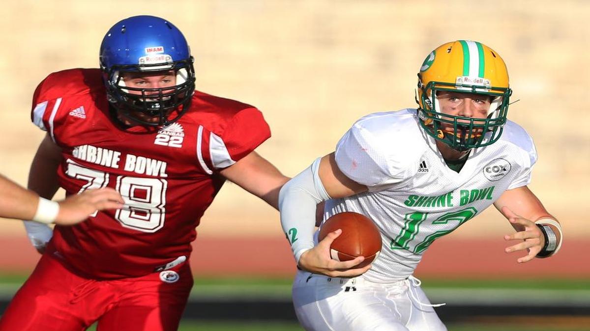 
West quarterback Colton Howell of Wichita Bishop Carroll (right) was chased by the East’s Mitch Holisinger of Olathe Northwest during the Kansas Shrine Bowl on Saturday in Hays, Kan.
