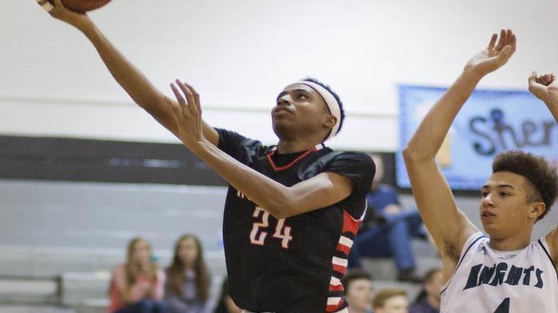Shawnee Mission North's Michael Weathers drove by Barstow's Shea Rush for a layup at the Shawnee Mission East Showdown on Dec 12, 2014.