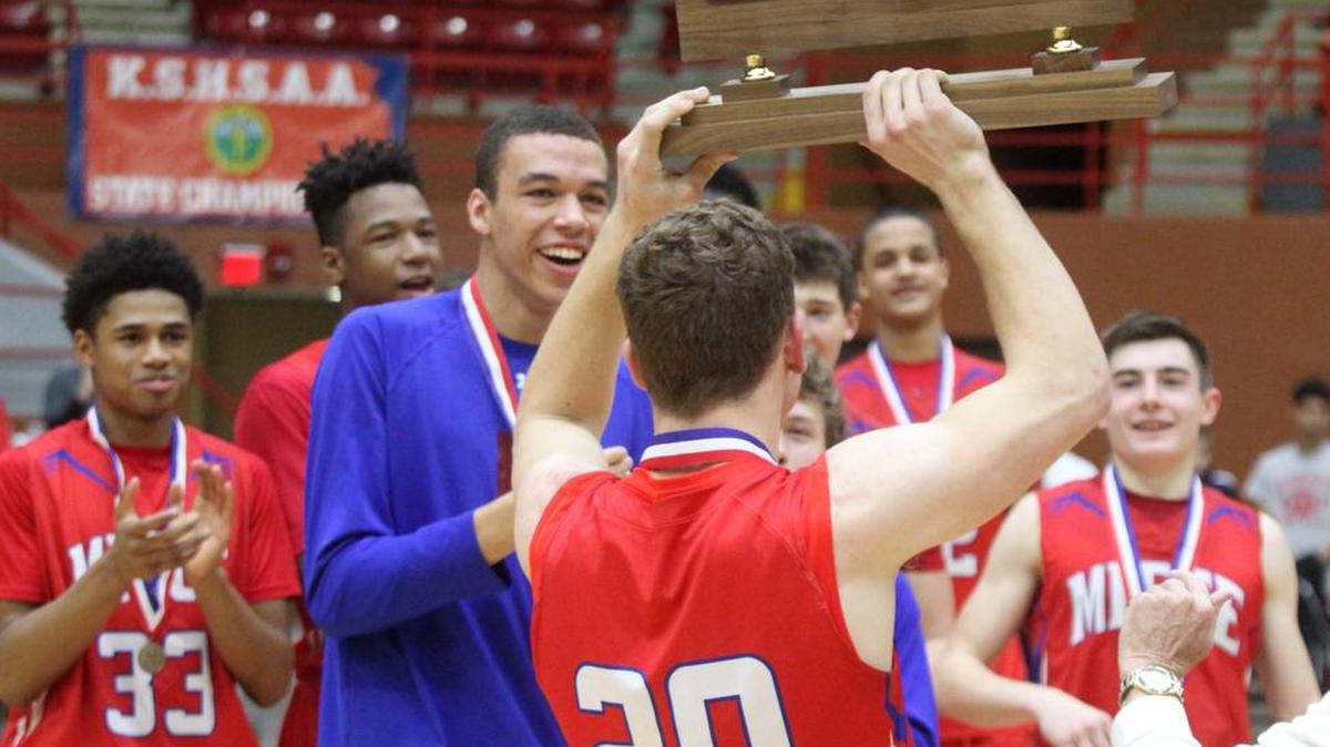Bishop Miege senior Dawson Downing (20) holds up the state championship trophy after the team's victory Sat. March 12, 2016 at the KSHSAA 4A State Championship at the Bicentennial Center in Salina.
