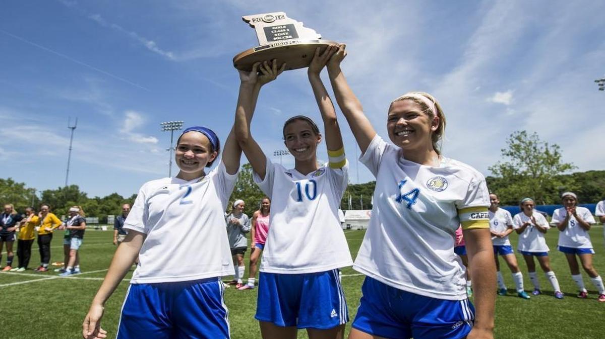 Sydney Routh (No. 2), Emma Meinking (No. 10) and Allison Malott (No. 14) of St. Pius X hold up their team’s third-place trouphy after defeating Notre Dame of St. Louis, 2-1, in the Missouri Class 2 state tournament on Thursday at Swope Soccer Village.