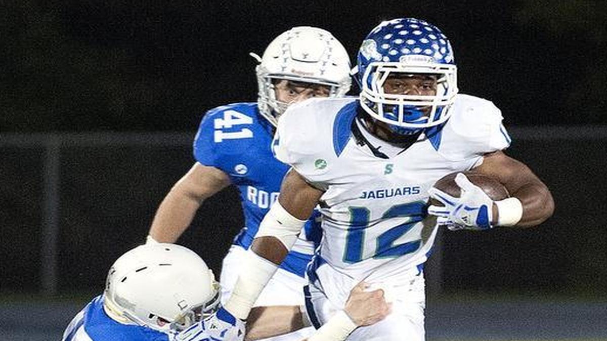 
Blue Springs South running back Adam Cofield ran around Rockhurst defenders in the first half Friday night. Blue Springs South defeated the Hawklets, 37-27.
