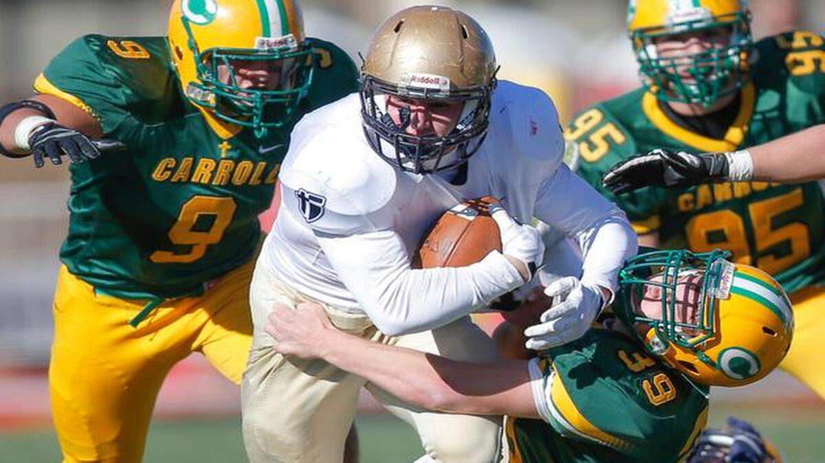 
Bishop Carroll’s Jarrett Johnson dragged down St. Thomas Aquinas’ Ben Ewing during the first quarter of Saturday’s game in Pittsburg, Kan. Bishop Carroll went on to a 39-7 victory.
