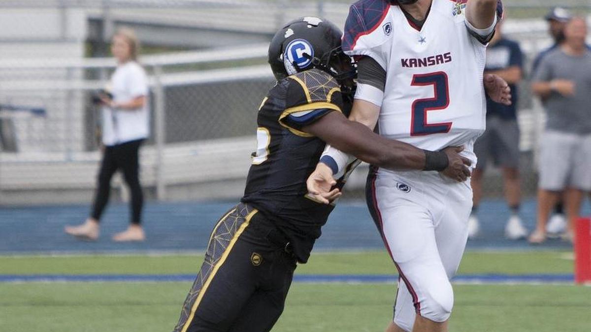 Kansas quarterbak Will Schneider of Shawnee Mission North just got this pass away in the grasp of Israel Smith of St. Joseph Central at the Kansas vs. Missouri High School All-Star Game June 15. Schneider was selected Kansas’ Most Valuable Player in its 17-7 loss to Missouri at Blue Springs South.