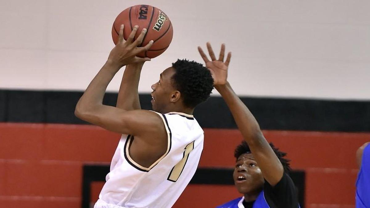 Lee’ Summit’s Nick Larkin (left) sailed by Central’s Tyvon Taylor on his way to the basket at the William Jewell Holiday Classic on Saturday night.