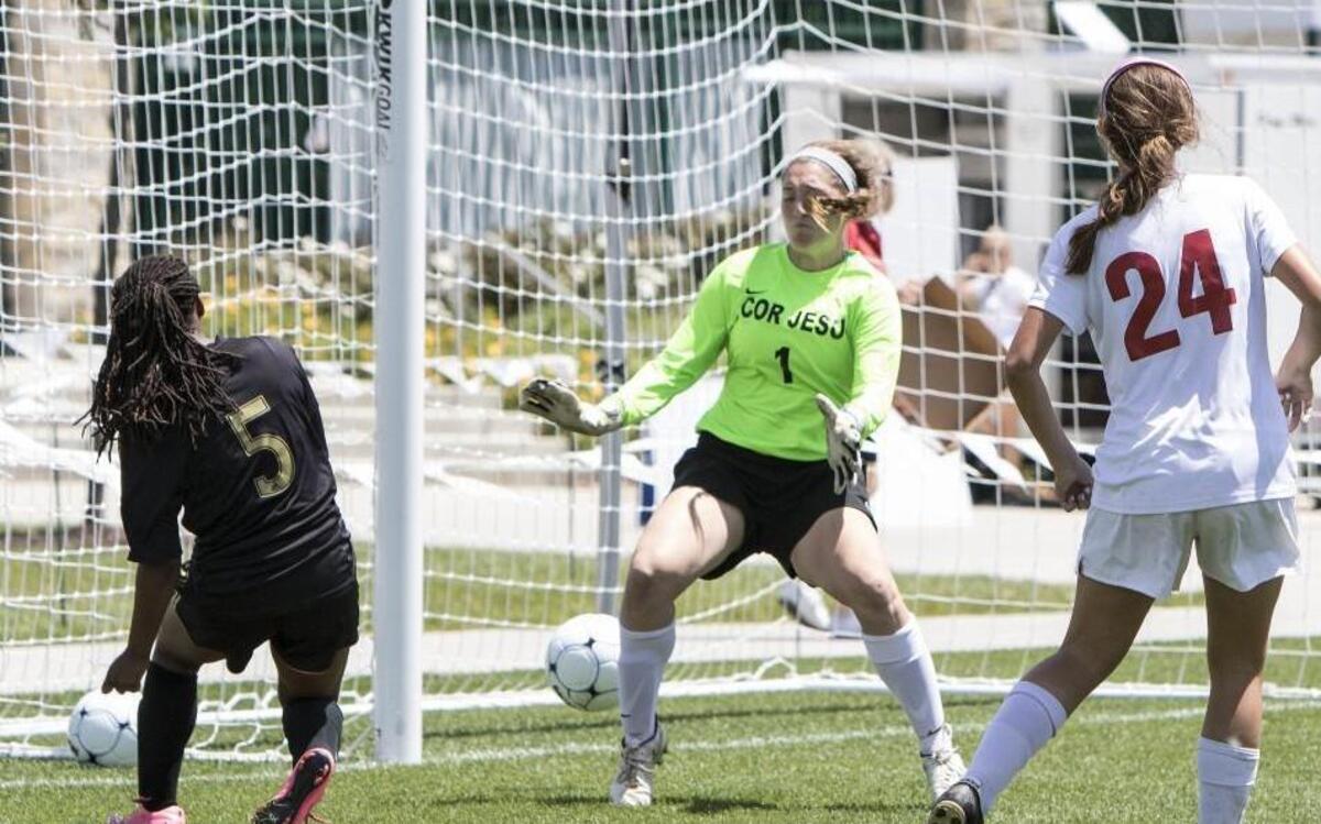 Lee's Summit's Kayla Deaver (left) slipped a ball into the goal in front of Cor Jesu goalie Elizabeth Slinkard at the Missouri Class 4 third-place game at Swope Park Soccer Village on Saturday. Lee's Summit won 4-1.