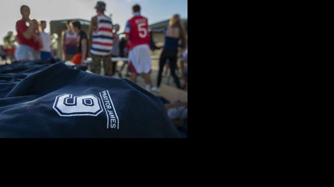 
Olathe East students and parents sell t-shirts with the words “Pray for James” before the start of SM South at Olathe East football game on Friday night at the College Boulevard Activity Center. Proceeds from the t-shirts will go to the James McGinnis Fund.
