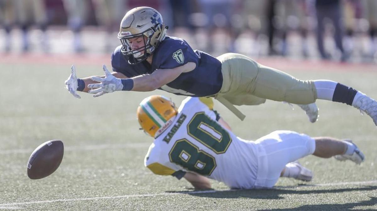 St. Thomas Aquinas defender Jared Flood tried for an interception over Bishop Carroll’s Brady Pacha during Carroll’s 38-28 win in the 5A state title in Pittsburg on Saturday.