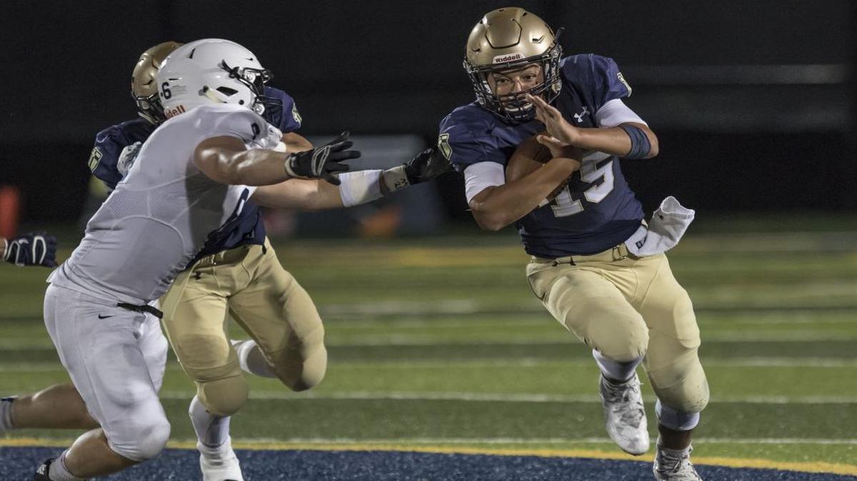 St. Thomas Aquinas's Will Swanson turns the corner in front of Mill Valley's Josh Winscott during Friday night’s contest at Aquinas.