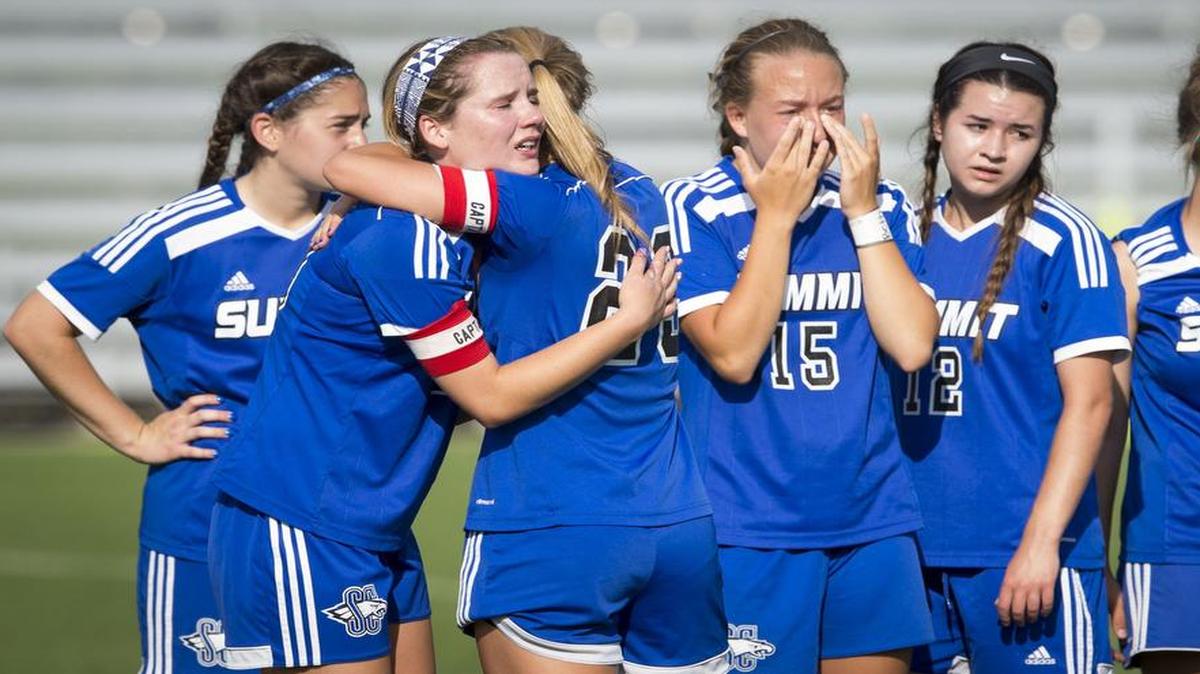 Summit Christian Academy forward Kassi Ginther (second from left) hugged teammate Savanna Sallas as the team lined up to receive the second-place trophy in Missouri Class 1 soccer on Thursday at at Swope Soccer Village.