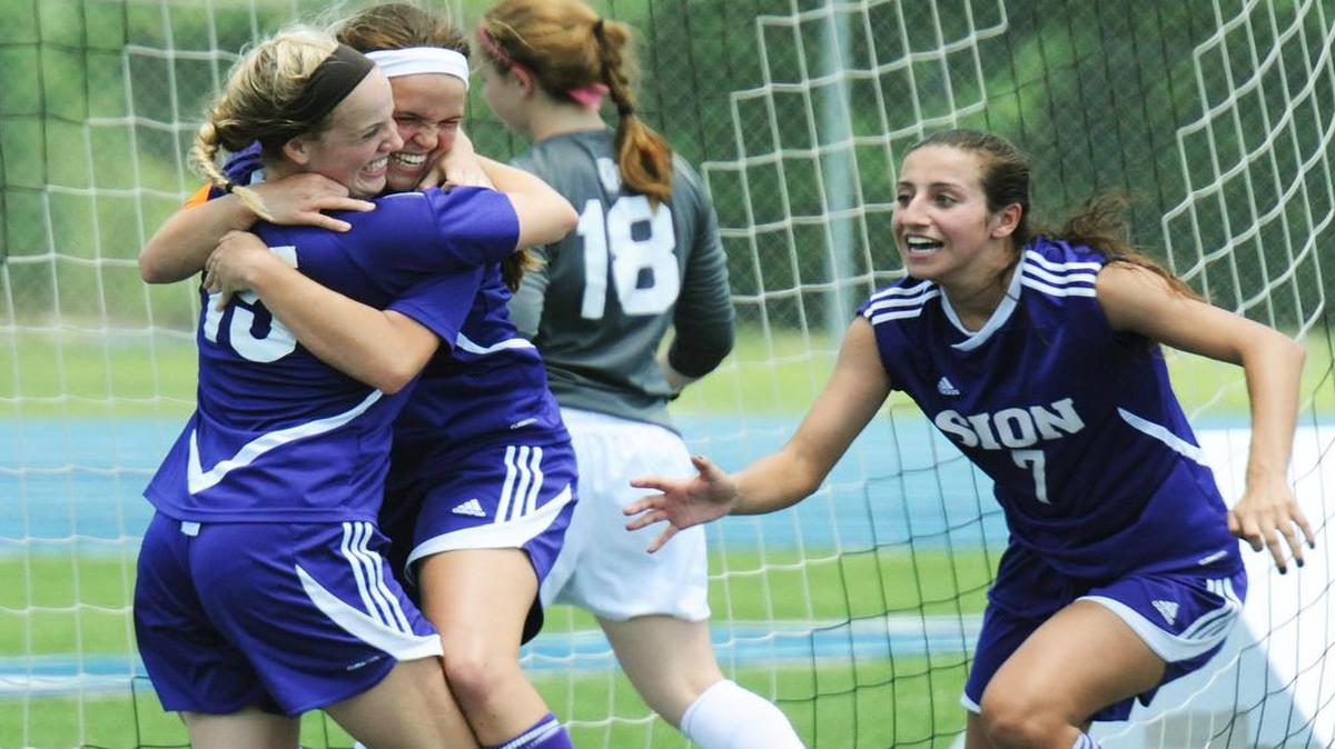 
Notre Dame de Sion’s Anna Romano (No. 15) hugs teammate Stephanie Ostrander, as Alexis Cutrera (right) approaches after Romano scored Sion’s second goal in a 2-1 victory over Webster Groves on Friday in a Missorui Class 3 state semifinal match at Blue Springs South High School.
