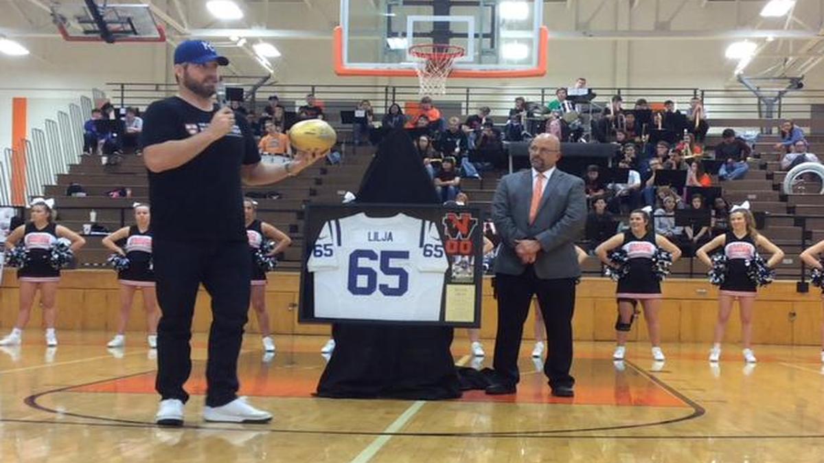 SM Northwest High School gradaute Ryan Lilja (left) presented the school with a Wilson golden football earlier this week as part of the NFL’s Super Bowl 50 celebration, which recognizes high school programs that have produced Super Bowl players and coaches.