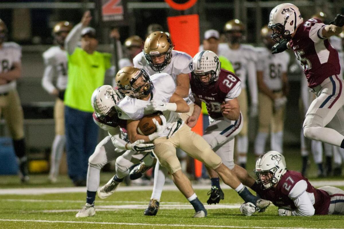 St. Thomas Aquinas running back James Consentino fights for a first down in the Saints’ game against St. James Academy on Friday night.