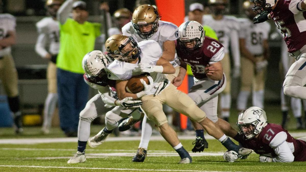 St. Thomas Aquinas running back James Consentino fights for a first down in the Saints’ game against St. James Academy on Friday night.