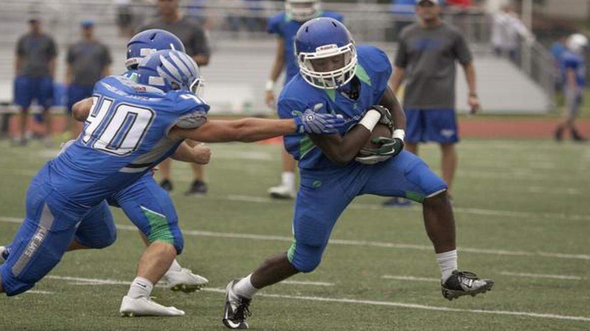 
Cole Kruse (right) of Raymore-Peculiar tried to avoid Adam Bryant and Charles Foster of Raytown at a high school football jamboree last month.
