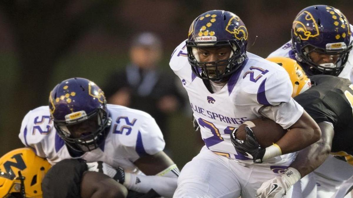 Jaylen Ivey (with football) of Blue Springs High School slipped through an opening in the line during a first-quarter run against Shawnee Mission West on Friday night. Blue Springs defeated the Vikings, 35-21.