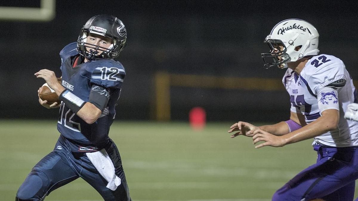Blue Valley North quarterback Joey Dolan (left) ran for yardage around Blue Valley Northwest’s Ryan Barnes during their game on Sept. 25 at Blue Valley District Activities Center. Blue Valley North won the game, 28-21.