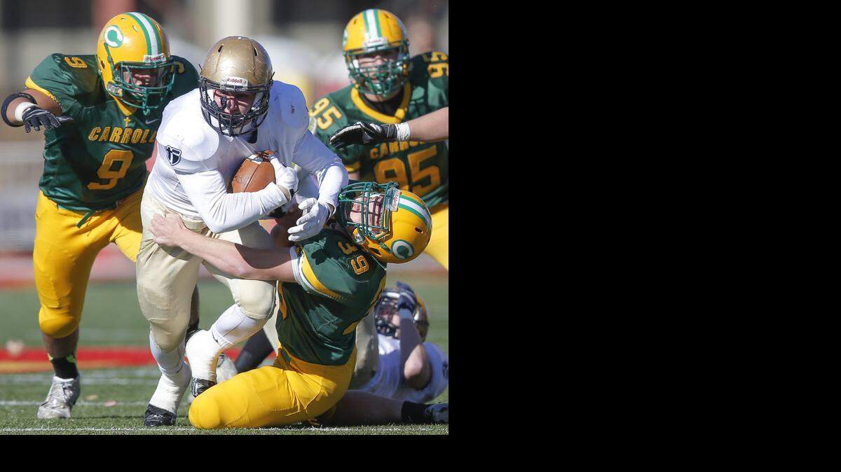 
St. Thomas Aquinas’ Ben Ewing (with ball) was dragged down by Bishop Carroll’s Jarrett Johnson in first-quarter action of their game on Saturday in Pittsburg, Kan.
