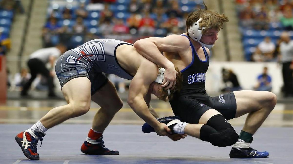 St. James’ Stephen Tujague, 138, left, grips the leg of Goddard’s Garrett Lange in the 5A state wrestling title match last February at Park City’s Hartman Arena.