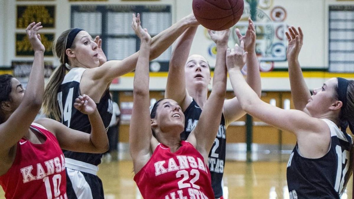 Missouri and Kansas players fight over a rebound on Friday during the Kansas vs. Missouri High School Basketball All Star Challenge girls game at Shawnee Mission South High School. Missouri defeated Kansas 56-54.