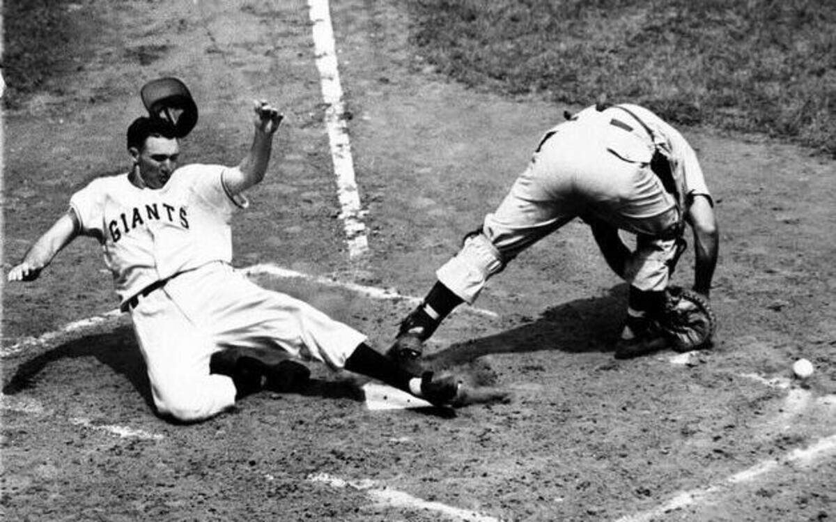 
In this June 24, 1950 file photo, the New York Giants’ Alvin Dark slid safely across home plate behind Cincinnati Reds catcher Dixie Howell for an inside-the-park home run.
