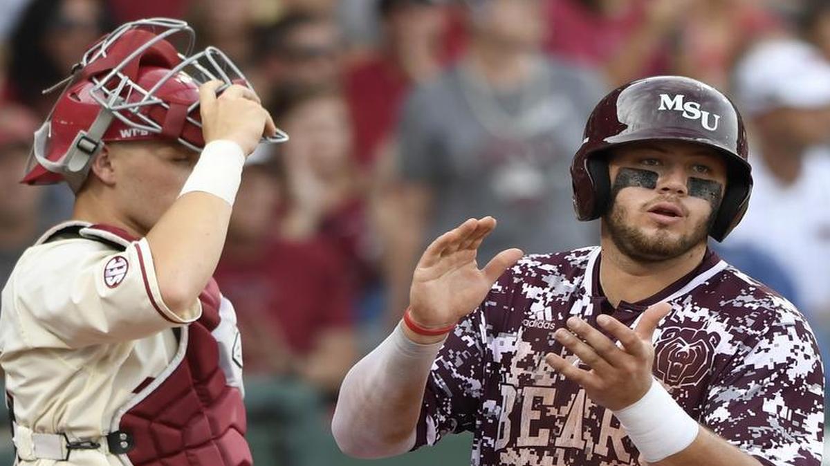 Missouri State’s Jake Burger celebrates in front of Arkansas catcher Grant Koch as he scores a run on a sacrifice fly in the fourth inning of an NCAA college baseball regional tournament game on Monday, June 5, 2017, in Fayetteville, Ark.