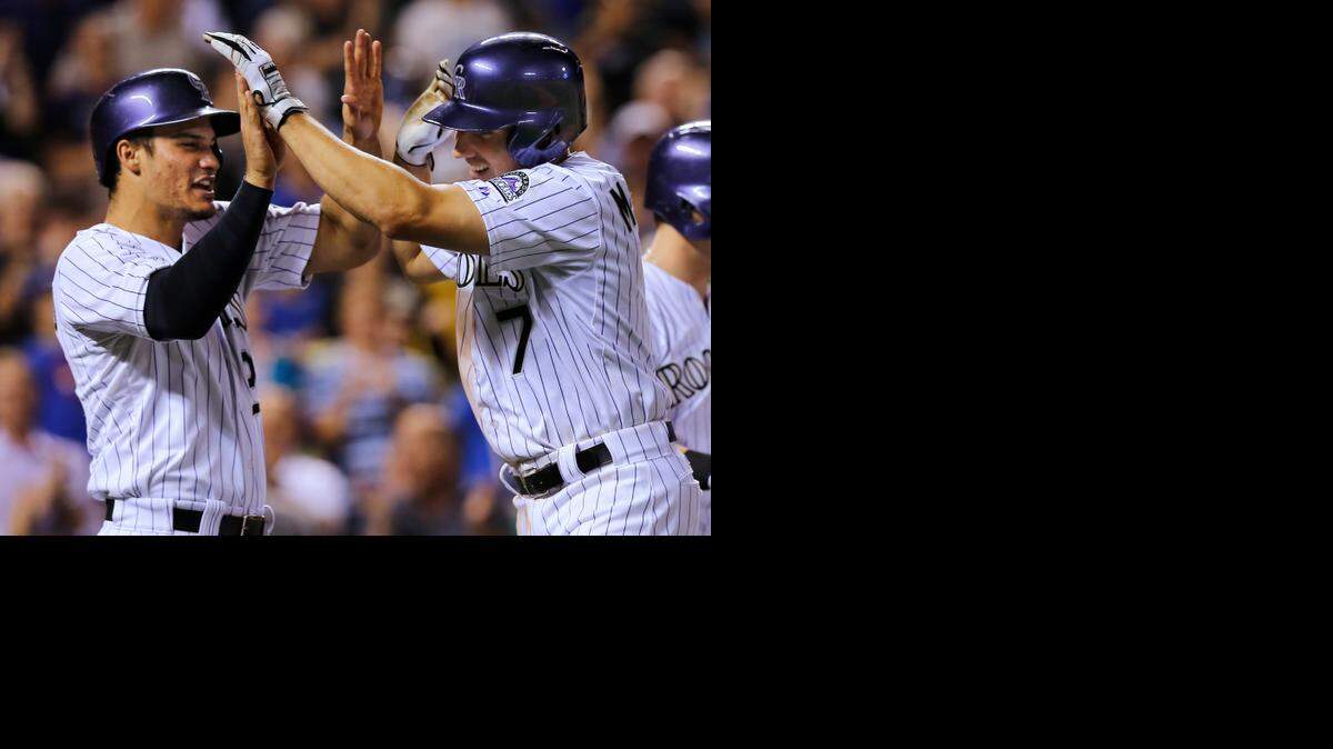 
Teammate Nolan Arenado (left) celebrated with the Colorado Rockies’ Matt McBride after McBride hit a grand-slam home run off Royals starter Danny Duffy in the sixth inning Wednesday night in Denver.
