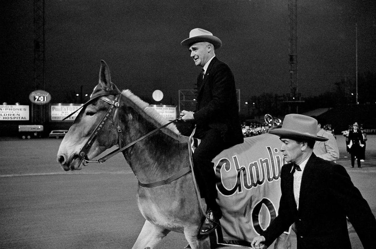 Kansas City Athletics owner Charlie Finley famously sits astride Charlie O, the team’s mule mascot, during pre-game ceremonies before his A’s play the Detroit Tigers on April 12, 1965, at Municipal Stadium.