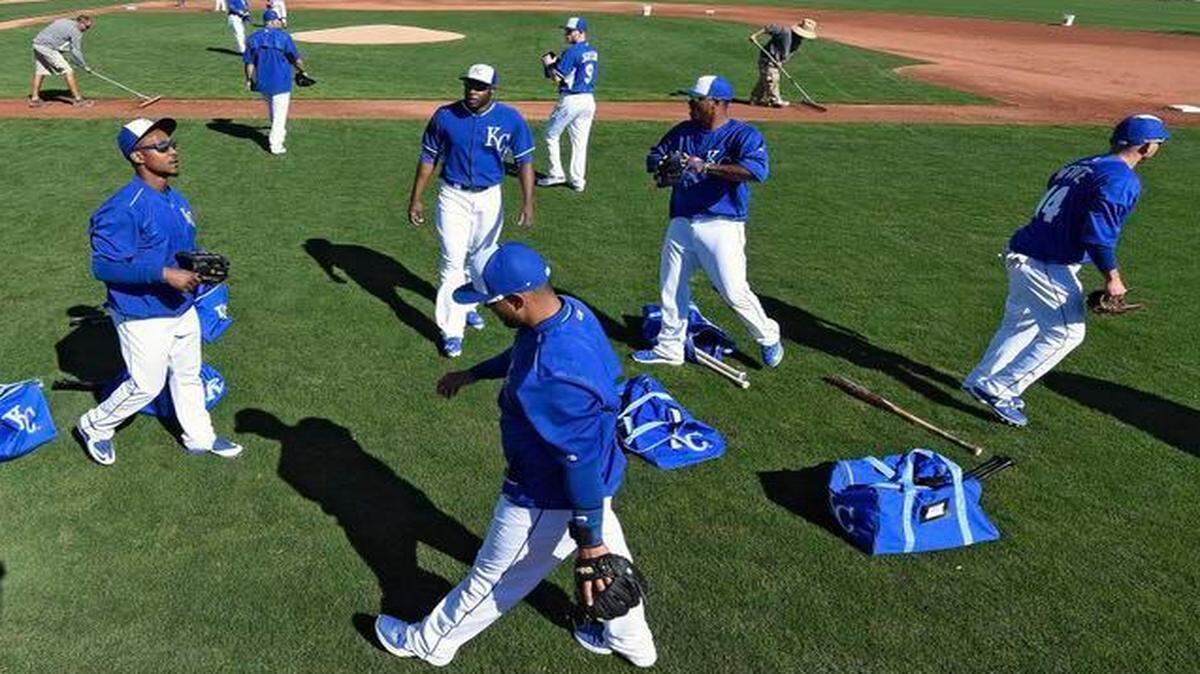 
Kansas City Royals players grab their gloves to start warming up during Wednesday’s spring training workout in Surprise, Ariz.
