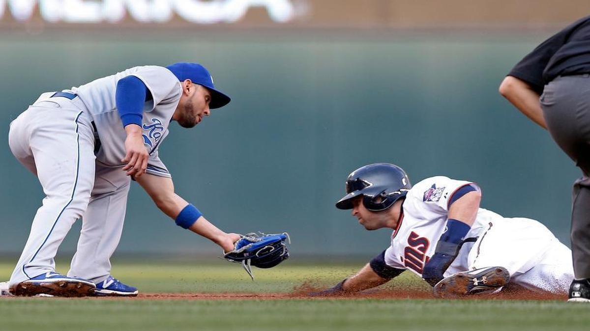 
The Twins’ Brian Dozier (right) slides into the waiting tag by Royals second baseman Omar Infante on a steal attempt in the first inning of Monday’s baseball game in Minneapolis.
