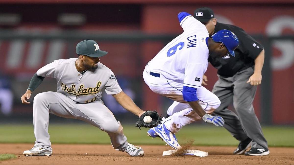 Kansas City Royals' Lorenzo Cain reaches second ahead of the throw to Oakland Athletics shortstop Marcus Semien on a double in the fourth inning during Wednesday's baseball game at Kauffman Stadium in Kansas City, Mo.