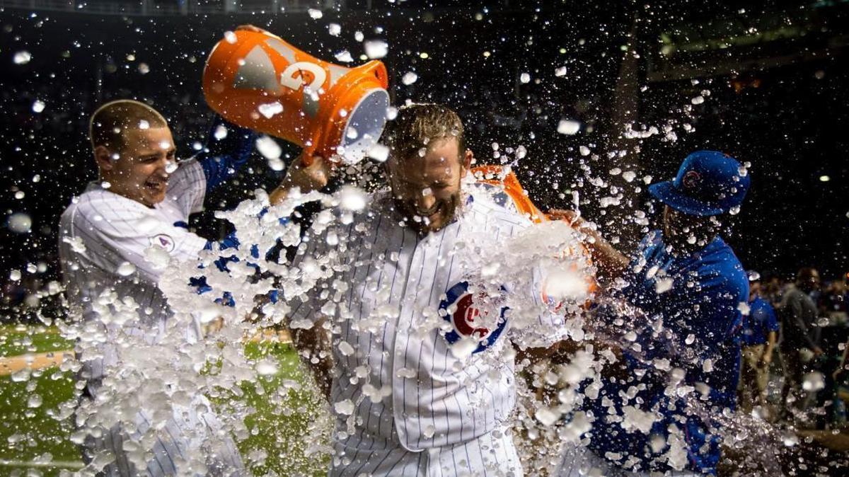 
Cubs teammates Anthony Rizzo (left) and Dexter Fowler drenched Chris Denorfia with water after Denorfia’s walk-off home run beat the Royals 1-0 in the 11th inning Monday night in Chicago.
