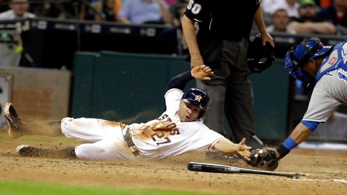 
The Astro’ Jose Altuve slided past the tag from Royals catcher Salvador Perez to score from third base on a fielder’s choice by Chris Carter in the seventh inning Wednesday night in Houston. The Astros beat the Royals 6-5 to sweep the three-game series.
